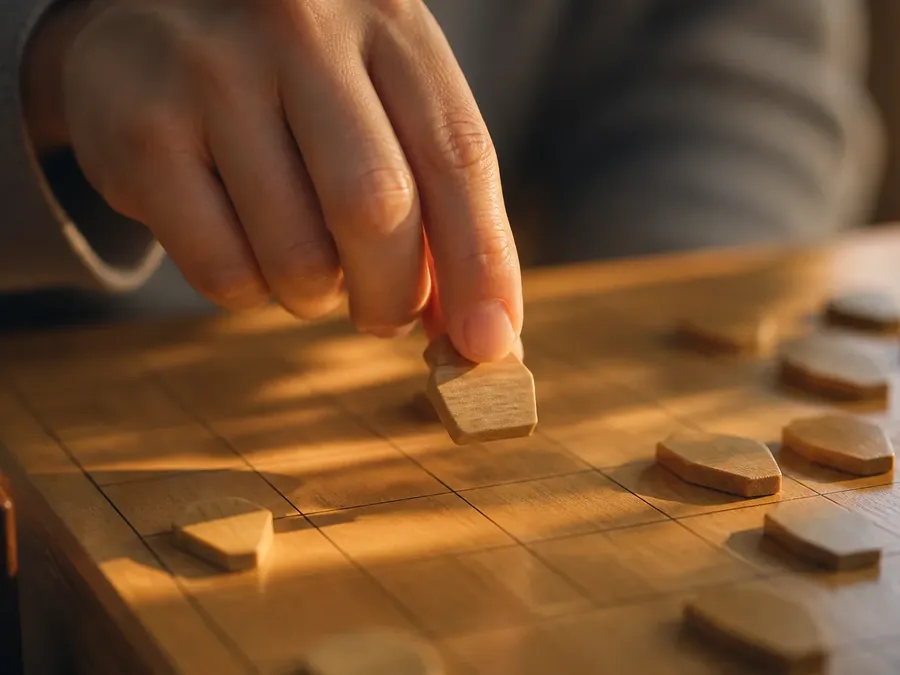 A hon-shogi piece being dropped from the hand onto an empty square